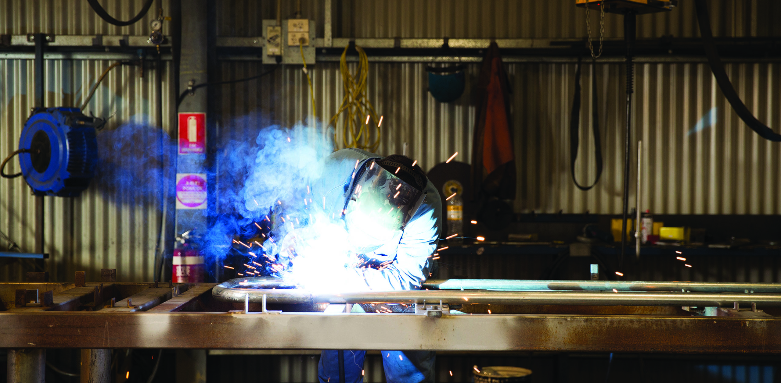 A Brennans Welding employee welding in a shed.